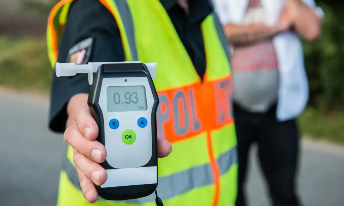 Policjant pokazuje alkomat z wynikiem 0.93 promila. To wynik, który jasno pokazuje, ile można mieć promili, by nie przekroczyć dopuszczalnej normy.