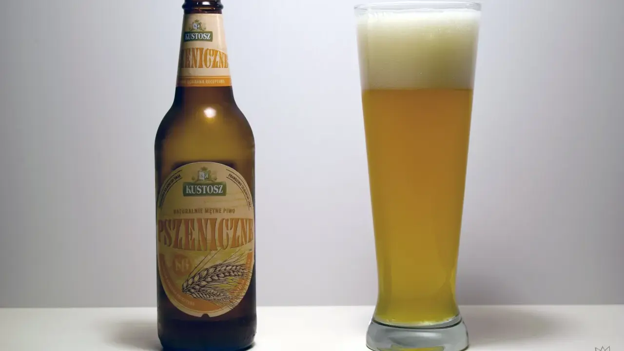 Kustosz piwo pszeniczne, naturalnie mętne, w butelce i szklance z obfitą pianką. Idealne na letnie popołudnie.