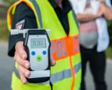 Policjant pokazuje alkomat z wynikiem 0.93 promila. To wynik, który jasno pokazuje, ile można mieć promili, by nie przekroczyć dopuszczalnej normy.
