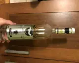 Butelka wódki Beluga Export, z etykietą "Noble Russian Vodka", leży na drewnianym blacie.