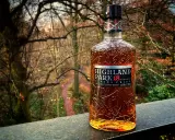 Butelka whisky Highland Park 18 Year Old na tle jesiennego lasu.